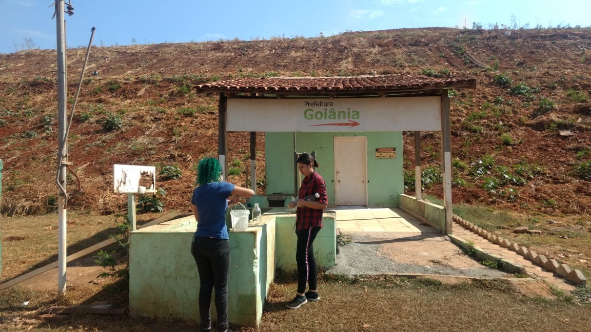 Alunas do curso de Engenharia Ambiental e Sanitária do Câmpus Goiânia do IFG durante análise no canal de medição da vazão do chorume produzido no Aterro Sanitário de Goiânia.